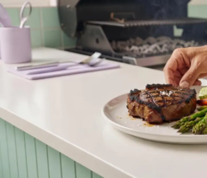 Charcoal-grilled steak being plated with colourful sides at Charcoal & Chips